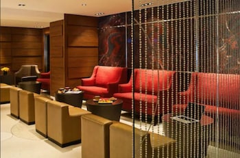A modern lobby with a reception desk, seating area, and a glass railing overlooking the interior. at The Pearl New York