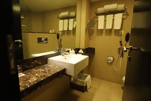 Bathroom features a sink, towels, and a handheld showerhead.