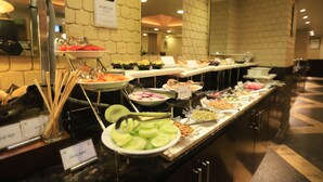 Een buffet met diverse gerechten, zoals salades, fruit en meer.