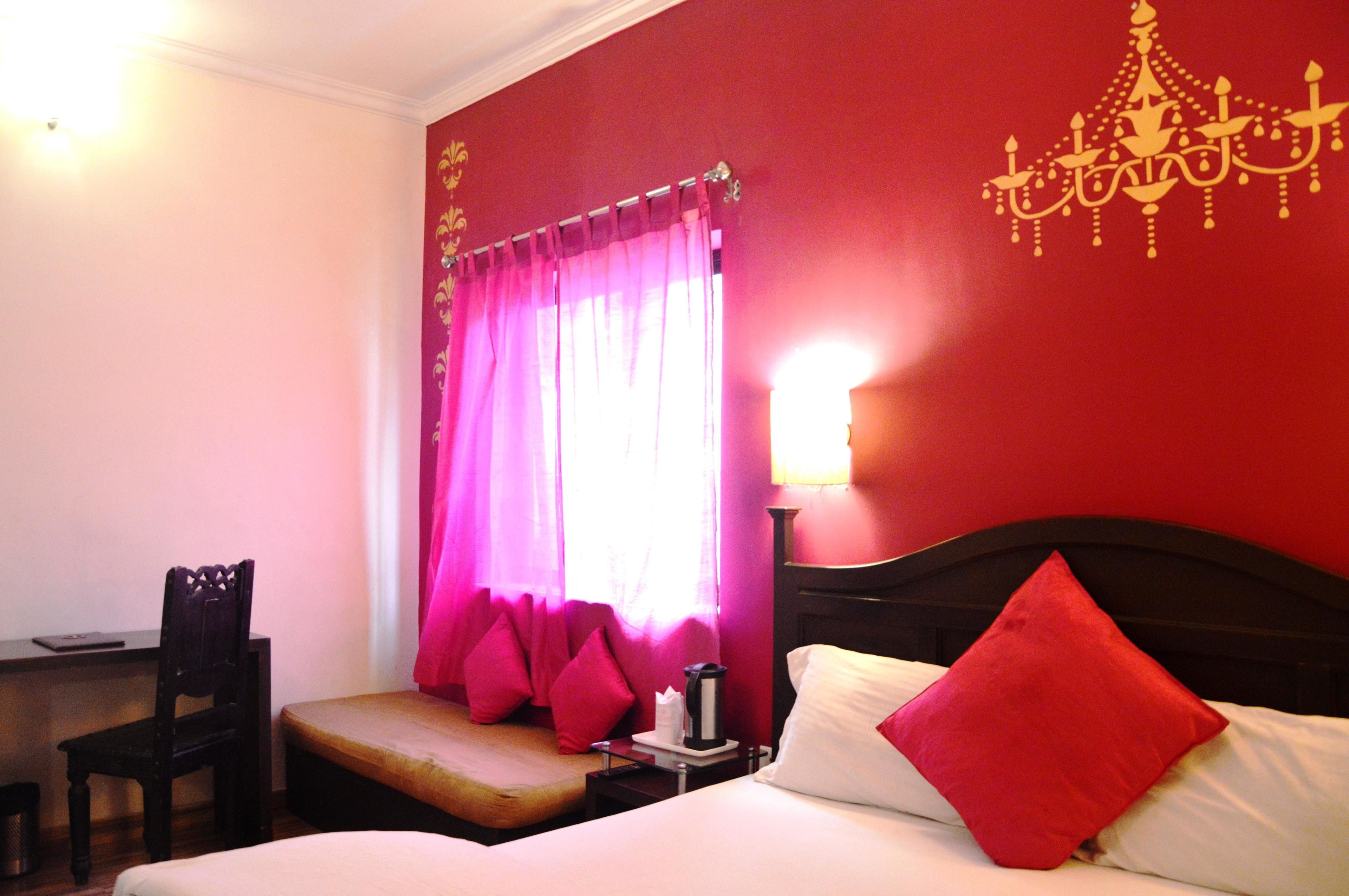A hotel room with a bed, a desk, and a chair.