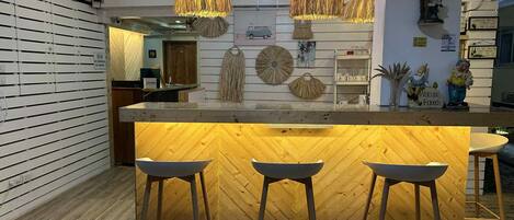 A modern kitchen with a wooden island, pendant lights, and a 'Welcome Friends' sign.