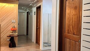 A hallway with wooden doors, a wooden wall, and a small table with a statue.