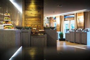 A modern kitchen with wooden accents, a fruit display, and a view of the outdoors. - Au Coeur du Village (La Clusaz)