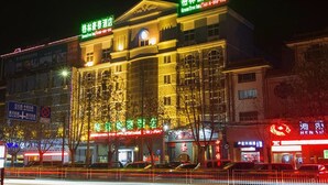 Un hotel de varios pisos, con letreros iluminados y una entrada destacada.