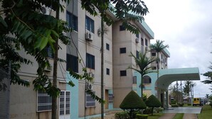 A multi-story building with a flat roof, air conditioning units, and barred windows. - Hotel Azur (Yaoundé)
