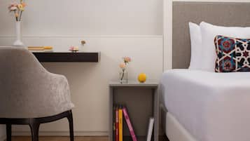 A neatly arranged bedroom with a bed, bedside table, and a chair.