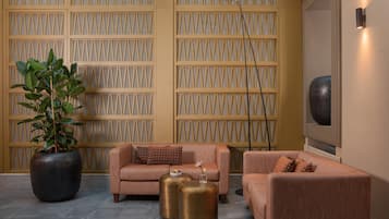 A modern interior with a sofa set, a large potted plant, and a decorative floor lamp.