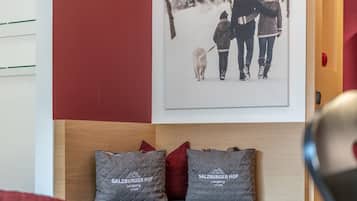 Una habitación con cabecera de madera, dos almohadas grises con texto y un cuadro enmarcado en la pared.