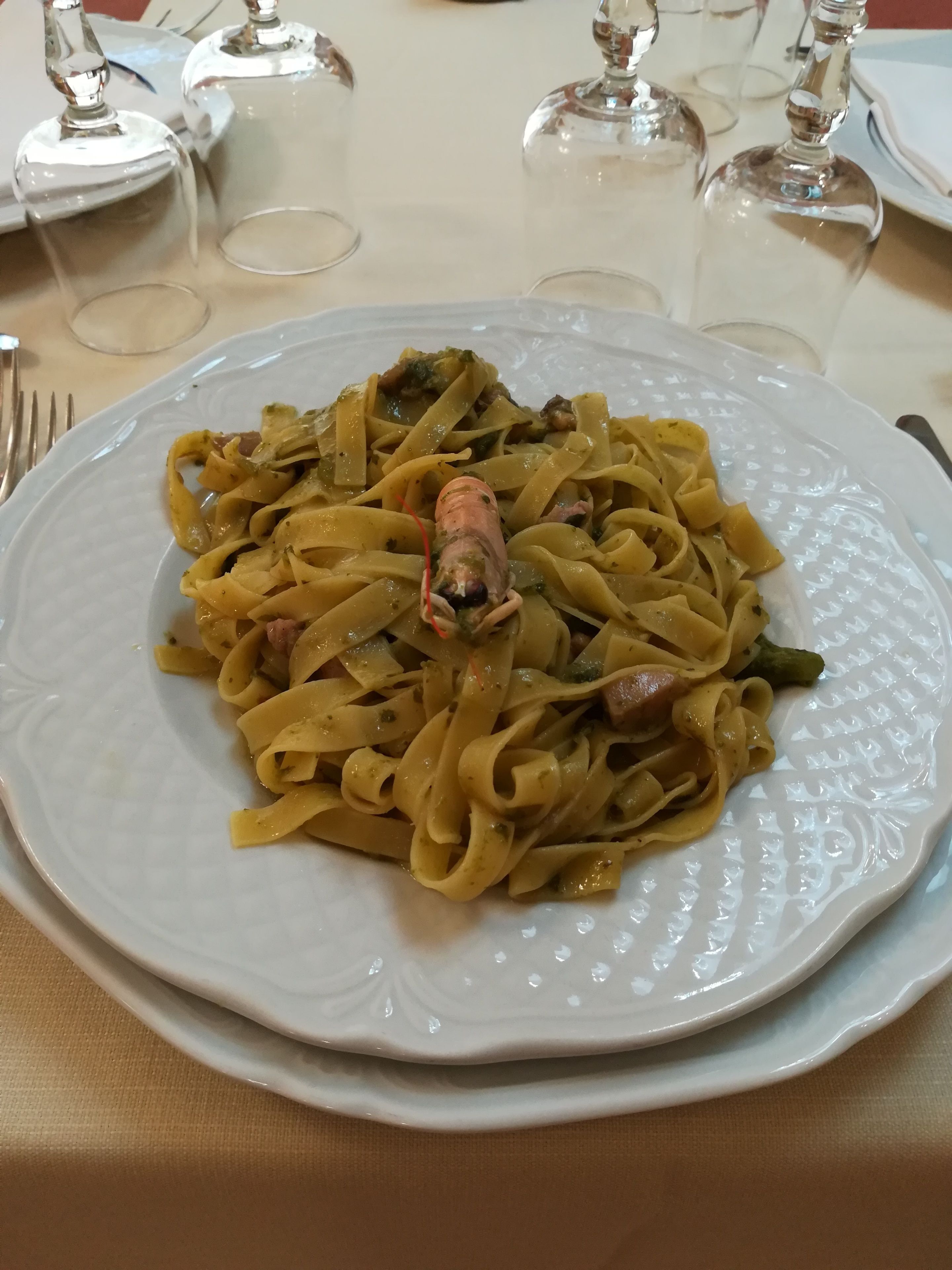 Un plato de pasta con un langostino.