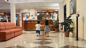 A hotel lobby with a checkered floor, a reception desk, and a sofa. - Hotel Euro (San Giovanni Rotondo)