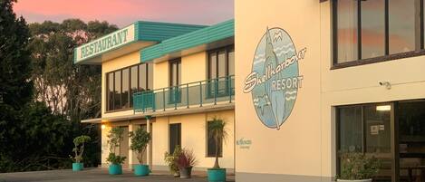 Un edificio con un letrero que dice "Shellharbour Resort" y "RESTAURANTE" encima.