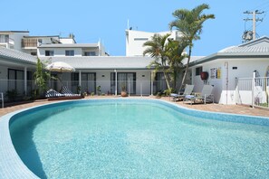 Alberca al aire libre, sombrillas en la alberca y camastros 