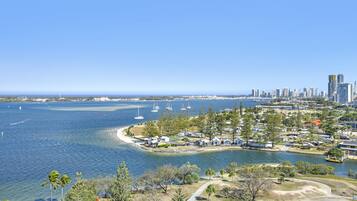A coastal area with a marina, beach, and a city skyline in the background.