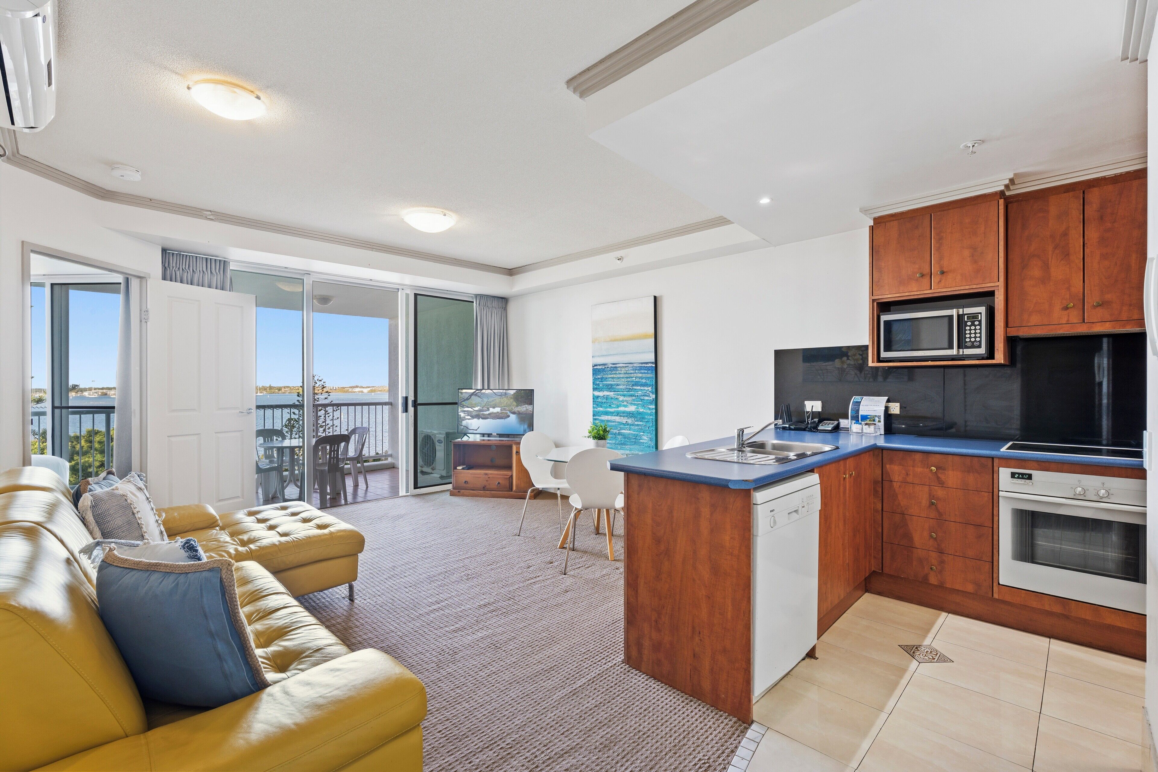 A modern kitchen with wooden cabinets, a built-in microwave, and a dishwasher.