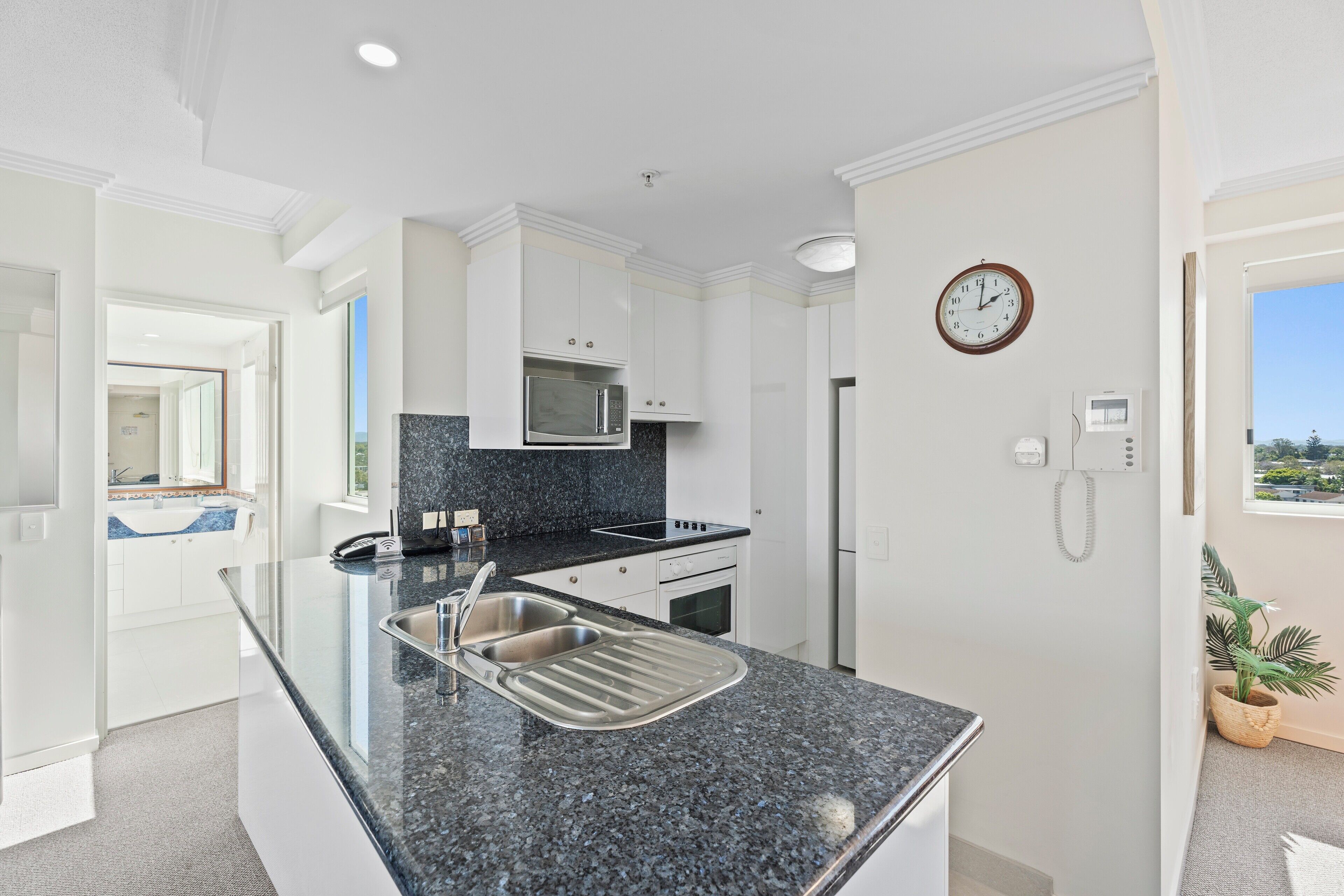 A modern kitchen with a granite countertop, stainless steel sink, and built-in appliances.