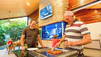A restaurant with a grill, a large fish tank, and a stone wall.