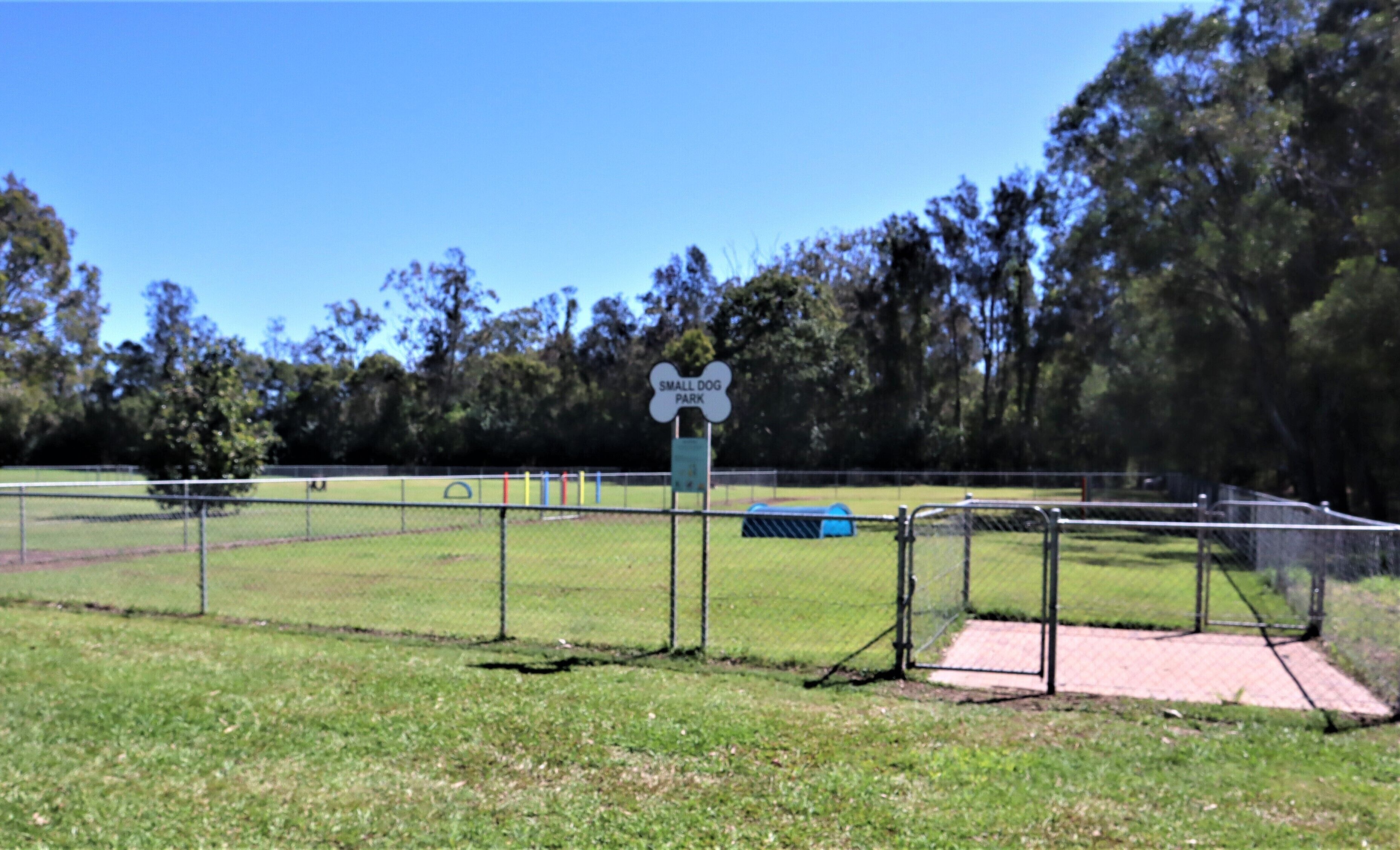A fenced area with a sign reading "Small Dog Park" and a blue play structure.