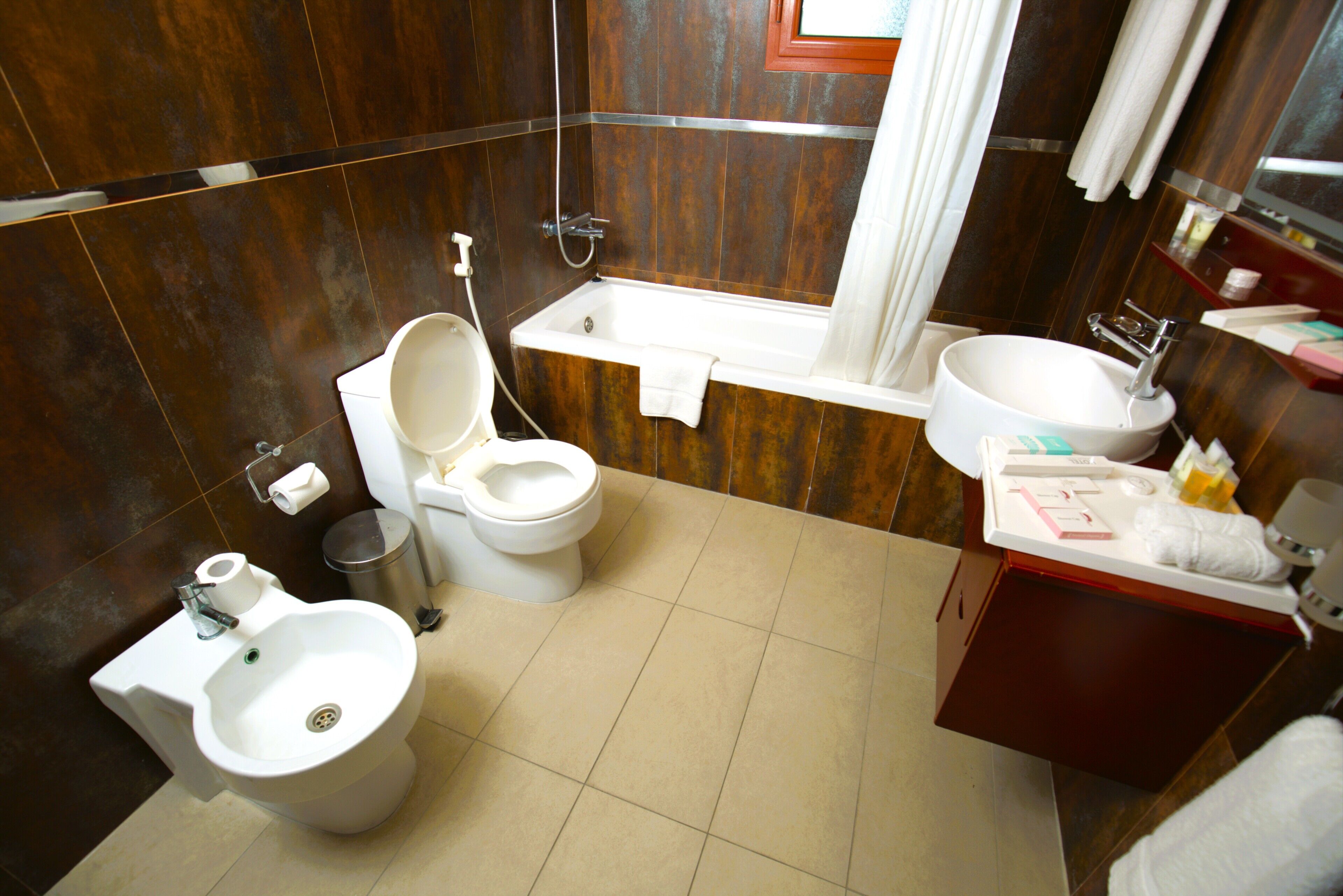 Un baño con inodoro, bidé, bañera y lavamanos.