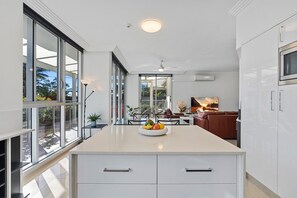 Apartamento Deluxe (Ground Floor) | Cocina privada | Frigorífico grande, microondas, placa de cocina y cafetera o tetera