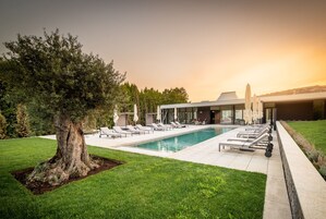 Una piscina al aire libre de temporada, sombrillas