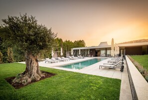 En sÀsongsöppen utomhuspool, parasoller och solstolar