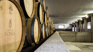 Wooden wine barrels stacked in rows inside a building.