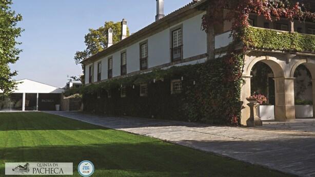A historic building with a paved courtyard, a covered outdoor seating area, and a well-maintained lawn.