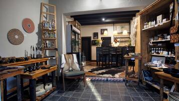 Un ambiente acogedor con una zona de bar, estantes con varios objetos y una alfombra estampada.