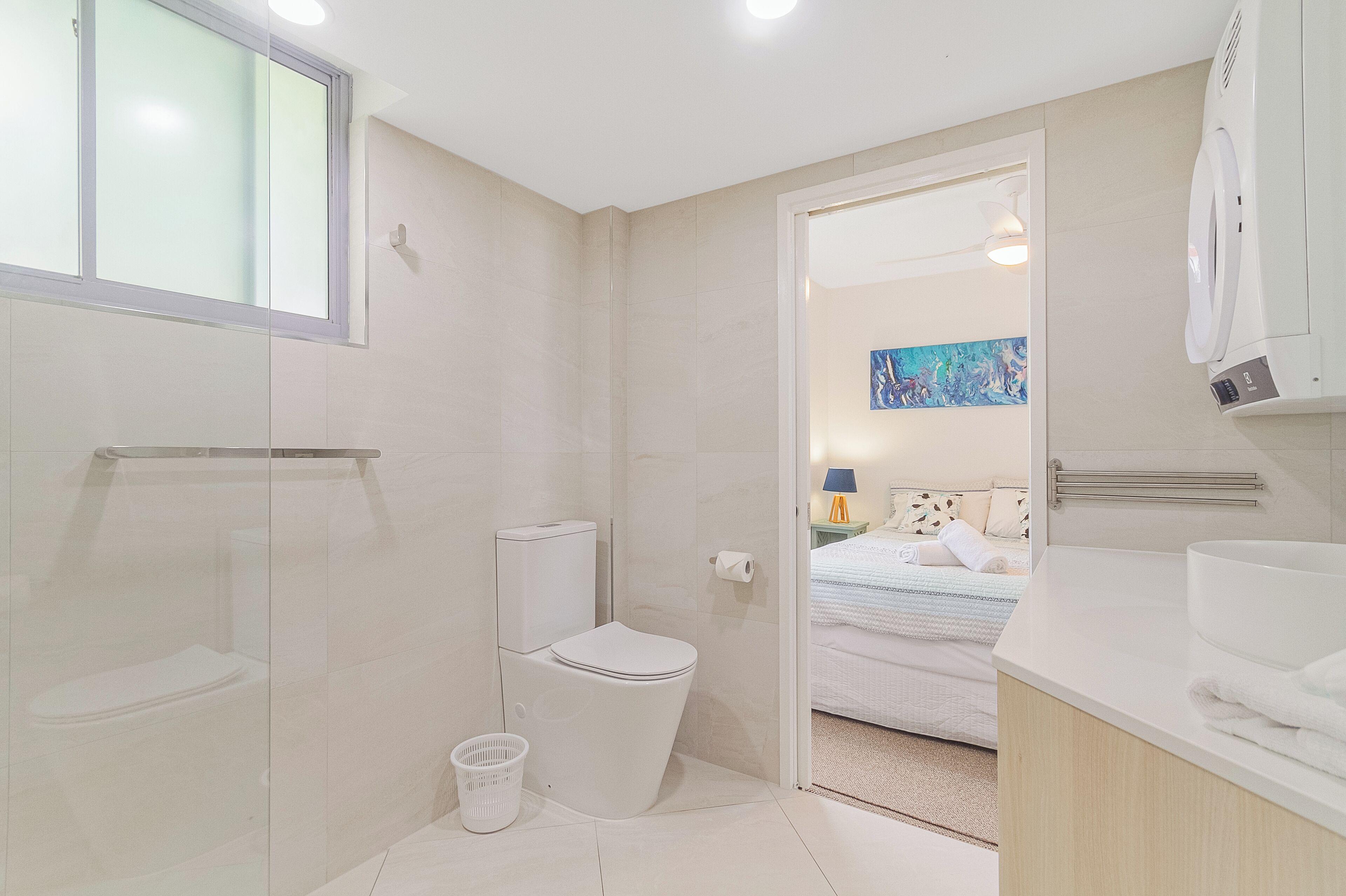 Een moderne badkamer met toilet, bidet en een groot wastafel.