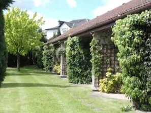 A row of stone buildings with a tiled roof, surrounded by well-maintained greenery and trees. - Castlecary House Hotel (Glasgow)