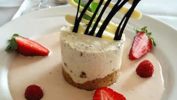 Postre amb freses i una salsa cremosa sobre un plat blanc.
