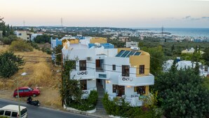 Un bâtiment moderne à deux étages, doté d’un toit plat, de panneaux solaires et d’une enseigne indiquant qu’il s’agit d’un restaurant.