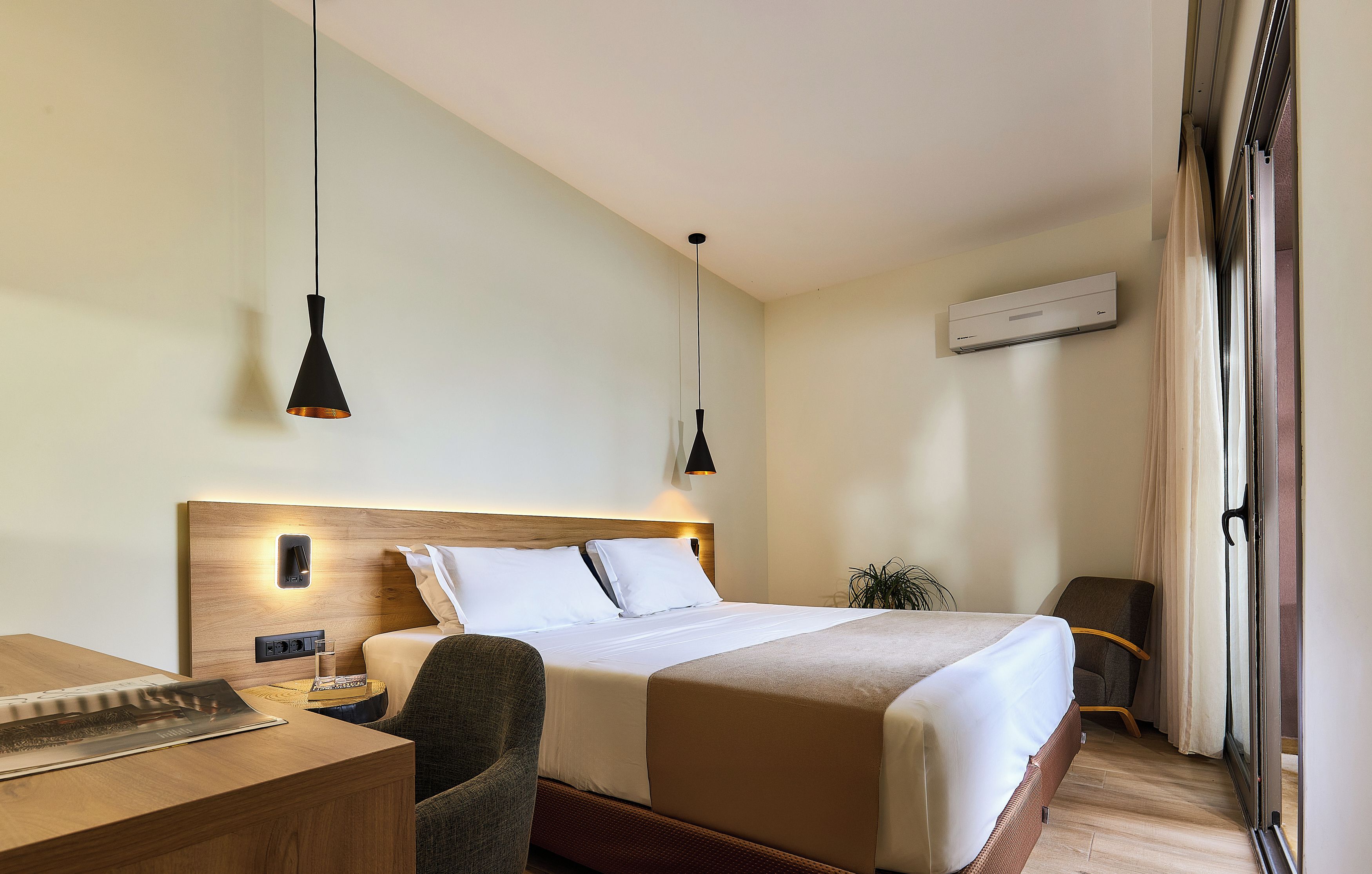 Una habitación de hotel con cama, mesita de noche, silla y escritorio.