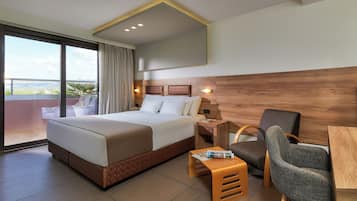 A hotel room with a large bed, a desk, a chair, and a view of the city.