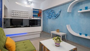 A modern living room with a sofa, a coffee table, a bookshelf, and a wall art piece.