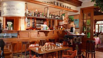 A bar area with wooden furniture, a chessboard, and a clock on the wall.