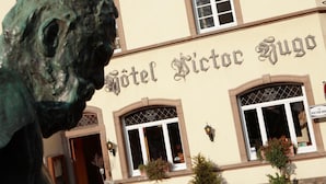 Hotel Victor Hugo with a prominent lion statue in front. - Hôtel - Restaurant Victor Hugo (Vianden)