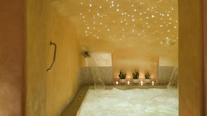 Un cuarto de spa con una bañera, un aplique de techo y dos plantas en macetas.
