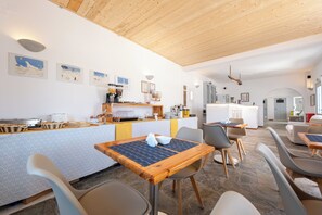 A modern dining area with a wooden ceiling, a buffet setup, and contemporary furniture.