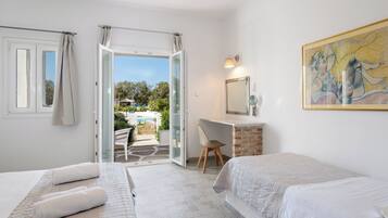 Un dormitorio con dos camas, un escritorio y una silla.
