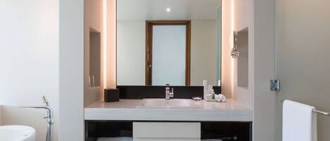 Une salle de bain moderne avec un double vasque, un miroir, un porte-serviettes et une étagère intégrée.