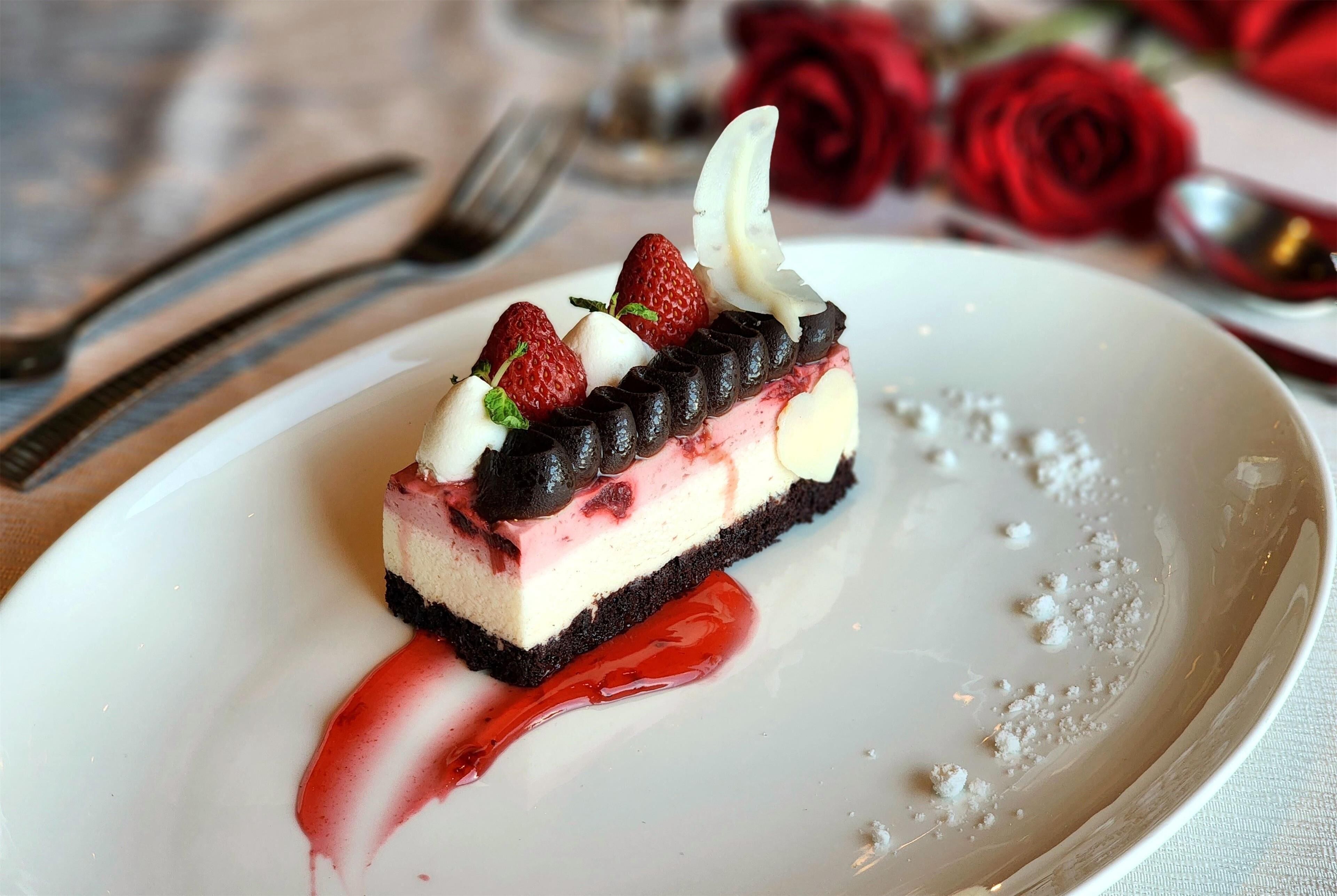 A dessert on a plate with strawberries and chocolate.