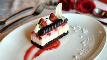 Un dessert servi dans une assiette, accompagné de fraises et de chocolat.