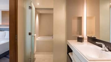 A modern bathroom with a glass shower enclosure, a bathtub, and a large mirror.