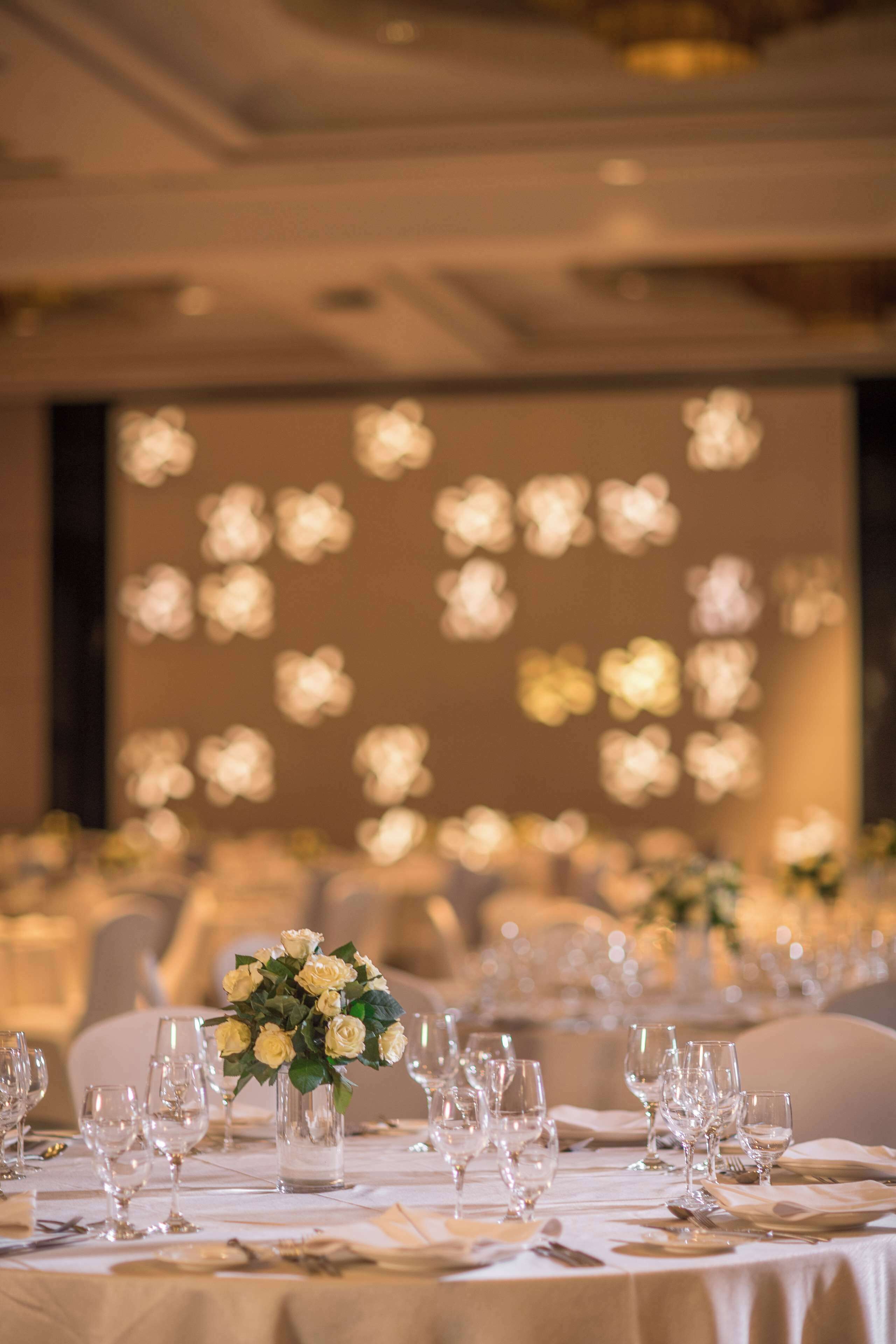 A banquet table set for a formal event with a floral centerpiece.