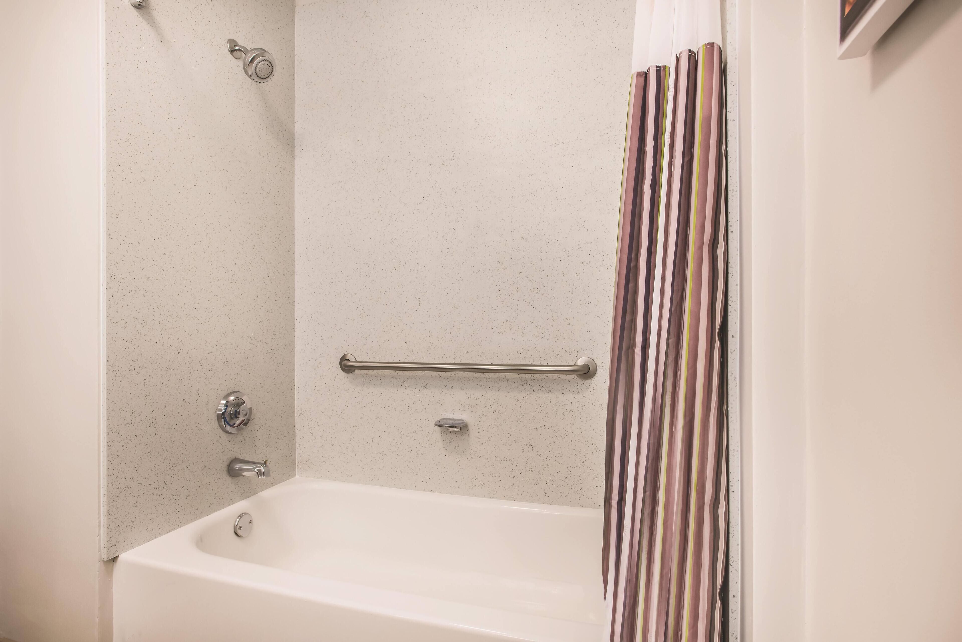 Un baño con bañera, ducha y perchero.