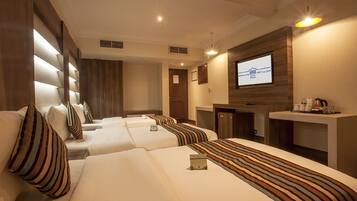 Habitación de hotel con dos camas, televisión, escritorio y minibar.