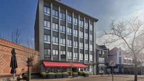 A hotel with a red awning, a brick facade, and a clear sky. - Hotel La Reine (Eindhoven)
