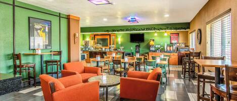 A restaurant with orange seating, green walls, and a tiled floor.