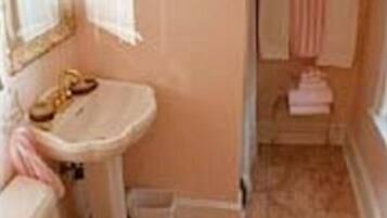 A bathroom with a toilet, sink, and mirror.